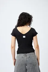 Remera gris de ribb con escote en V, mangas cortas con dobladillo, corte cropped y textura canelada.