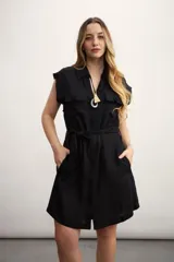 Vestido camisero corto negro con cuello clásico, solapas, cierre frontal con botones, cinturón de lazo y bolsillos laterales.