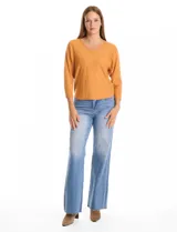 Buzo de tejido fino con escote en V, mangas tres cuartos estilo dolman y corte holgado.