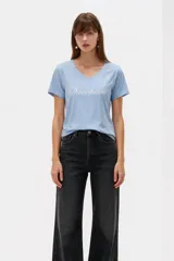 Remera negra de algodón, con cuello en V, mangas cortas, corte al cuerpo y estampa frontal con la frase "Emotionally Unavailable" en letras rosadas.