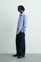 Camisa slim fit de algodón color celeste, con cuello italiano, manga larga y puños con botón. Cierre frontal de botonadura.