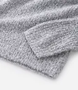 Suéter de punto texturizado color gris claro, con cuello polo y cierre frontal de botones. Presenta mangas largas con puños ajustados y un diseño de corte clásico.
