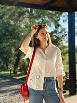 Bandolera roja de cuero con forro de tela, con bolsillo interior y exterior.