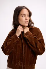 Campera de terciopelo color marrón chocolate, con cierre frontal, bolsillos laterales y elástico en el ruedo. Presenta un diseño de corte holgado con costuras marcadas.
