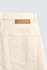 Jeans de hombre color beige claro, tiro medio, corte balloon fit con pierna relajada que se estrecha ligeramente hacia el bajo. Confeccionados en denim rígido de algodón, con cinco bolsillos y cierre frontal de cremallera y botón.