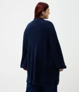 Cardigan abierto de punto pesado con textura peludita, manga larga y diseño alargado. Prenda versátil de corte holgado.