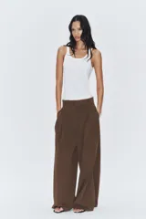 Pantalón de tiro medio color marrón, con pinzas en el delantero, perneras anchas de corte recto y trabillas para cinturón. Cuenta con bolsillos laterales y traseros, y cierre frontal con cremallera y botón.