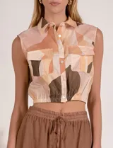 Top camisero corto estampado de marca Elan, sin mangas, con cuello camisero y cierre frontal de botones. Cuenta con dos bolsillos en el pecho con solapa y cintura elastizada fruncida.