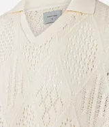 Camisa polo de mangas cortas color crema, confeccionada en tejido de punto calado con cuello inglés.