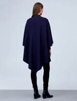 Ruana negra de tejido suave, con cierre frontal de botones metálicos y ribetes de cuero sintético en los bordes.