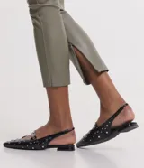 Pantalón tipo legging de mujer, color crema claro, confeccionado en poliuretano (PU) con un diseño liso. Presenta un cierre frontal con botones visibles en la cintura.