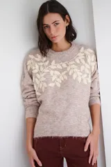 Buzo de tejido de punto en color beige, con cuello redondo y mangas largas. Presenta un delicado bordado de ramas y hojas en color crema en la parte superior del frente.