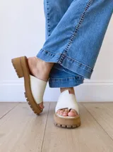 Sandalias de cuero crudo con tira ancha sobre los dedos y suela track color caramelo.