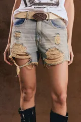 Short de denim negro de tiro alto, con roturas y flecos en el ruedo.