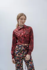 Pantalón de vestir de tiro alto, color rojo con estampado de flores grandes en tono marrón oscuro. Diseño recto con cordones ajustables en la cintura.