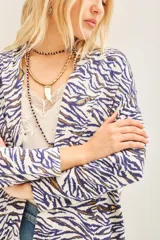 Saco tipo cardigan abierto de tejido liviano con estampado animal print en tonos azul y blanco. Presenta detalles bordados con lentejuelas a lo largo del diseño.
