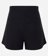 Short de bengalina color negro con cintura estructurada, detalle de botones decorativos y cierre frontal. Presenta un corte evasé que aporta volumen y estructura a la silueta.