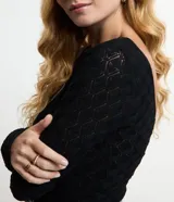 Blusa de manga larga, color blanco, con cuello redondo y textura de punto calado con diseño geométrico.