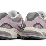 Championes urbanos New Balance modelo 2010, color rosado con detalles en gris y blanco. Confeccionados en una combinación de gamuza y malla, presentan el logo N característico en los laterales y una entresuela con tecnología de amortiguación visible en el talón.