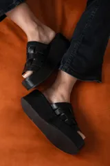 Sandalias de cuero Agnès Lenoble con plataforma plana y suela de madera, capellada con tiras doradas entrelazadas.