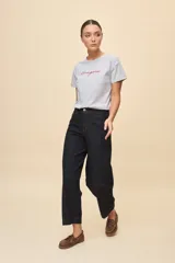Jean fit barrel de tiro alto, color azul oscuro, con silueta amplia que se estrecha sutilmente hacia el tobillo, costuras contrastantes y diseño moderno.