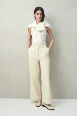 Pantalón de corte recto confeccionado en algodón, con diseño de tiro alto, bolsillos delanteros amplios y cierre frontal con botones.