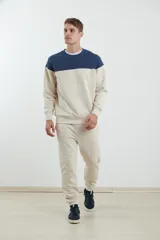 Sweater deportivo de hombre con escote redondo, diseño colorblock con la parte superior en gris claro y el cuerpo y mangas en negro. Presenta puños y cintura elastizados.