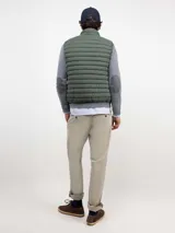 Chaleco acolchado de hombre confeccionado en nylon reciclado, con cierre frontal de cremallera, sisas elásticas y bolsillos laterales con cierre.