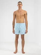 Short de baño celeste con rayas verticales blancas y estampado de flores blancas.