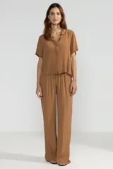 Pantalón de crepe color marrón, de corte recto con cintura elastizada y bolsillos laterales.
