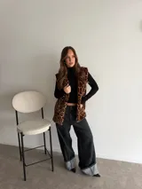 Chaleco de piel sintética con estampado animal print de leopardo, sin mangas y diseño largo.