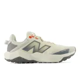 Championes New Balance Nitrel V6 de mujer, diseñados para trail running y senderismo, en color beige con detalles en gris y toques en naranja. Capellada de malla transpirable con tecnología Toe Protect y suela AT Tread con entresuela DynaSoft.
