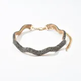 Gargantilla dorada con tejido de red metálica y apliques de strass negros.