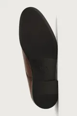 Zapato de vestir estilo Derby en piel color marrón oscuro, con cordones del mismo tono, horma redonda y suela con ligero tacón.