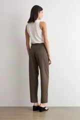 Pantalón de vestir marrón de corte barrel, con pinzas frontales marcadas y botamanga recta.