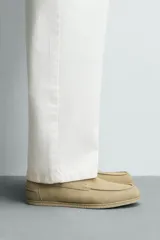 Zapato estilo náutico de hombre, color verde oliva, fabricado en piel con acabado serraje (gamuza). Presenta detalle de bordón en el empeine y horma redonda.