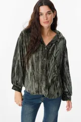 Camisa de manga larga confeccionada en terciopelo con acabado arrugado. Presenta cuello clásico, cierre frontal con botones y puños abotonados.