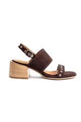 Sandalias de gamuza marrón con taco cuadrado de madera, tira ancha en el empeine y tira ajustable en el talón con hebilla metálica. La tira delantera presenta detalles de ojalillos metálicos plateados.