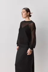 Falda midi color negro al bies, confeccionada en tela de textura suave y caída fluida, de diseño minimalista y silueta recta.