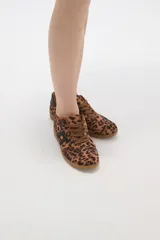 Zapatillas urbanas con estampado animal print de leopardo, cordones al tono y detalles de franjas laterales en color negro. Presentan suela de goma color caramelo y cuello acolchado.