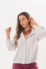 Camisa beige a rayas finas de manga larga, con cuello camisero y cierre frontal oculto.