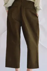 Pantalón cropped de tiro medio con diseño de pinzas en el delantero, trabillas para cinturón, bolsillos laterales y bolsillos de vivo en la parte trasera. Cierre frontal con cremallera y botón.