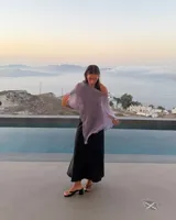 Poncho ligero de tejido de punto fino, color lila claro con brillo sutil, de forma asimétrica.