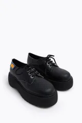 Zapato blucher acordonado de piel color blanco con ojetes metálicos y etiqueta textil personalizada en el lateral. Plataforma de goma logotipada color negro.