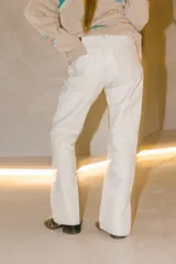 Pantalón de cuero de corte recto y tiro medio, color verde oscuro, con diseño artesanal y botón frontal.