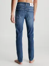 Jeans de mezclilla elástica de algodón, color azul medio con efecto desgastado y lavado. Presentan un corte skinny fit, cintura de talle bajo, bragueta con cremallera y estilo de 5 bolsillos.
