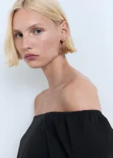Blusa negra de diseño crop con escote palabra de honor, mangas cortas abullonadas y cintura elástica.