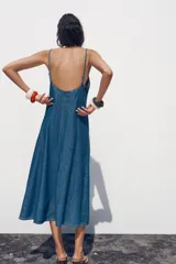 Vestido midi de denim azul, con escote en pico y tirantes finos.