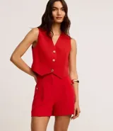 Short sastre de cintura alta con estructura definida, bolsillos laterales decorados con tachuelas metalizadas y recortes delanteros con costura aparente.