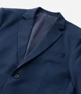 Saco de traje masculino de corte slim, confeccionado en poliviscosa con textura acanalada leve. Presenta cuello con solapa, cierre frontal con botones, mangas largas y bolsillos laterales. Incorpora tecnología performance para mayor respirabilidad y secado rápido.
